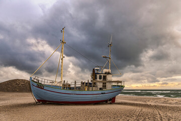 Naklejka premium Fishing boats pulled ashore before the arrival of a late summer storm. Thorupstrand fishermen support sustainable fishing. Thorupstrand, North Jutland, Denmark.