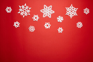 Christmas decoration with white paper snowflakes on red