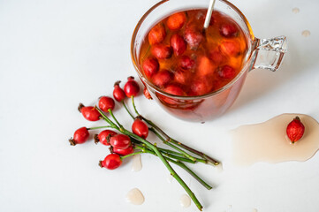 Rosehip tea, twig of fruit, surface of tea is in motion.
