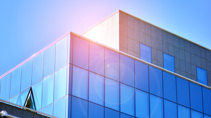 Corporate architecture building. New modern office building. Textured blue pane of contemporary glass architectural building. Sunlight.