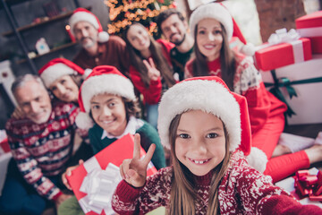 Photo of wife husband retired pensioner married small preteen school people xmas wear santa claus hat v-sign make selfie indoors