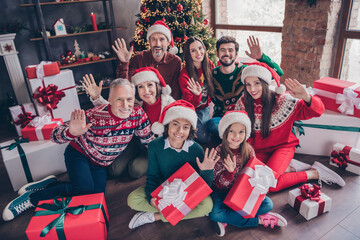 Portrait of attractive cheerful family holding giftboxes waving greetings eve advent party time at home indoors