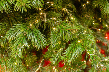 close up of christmas tree wit sparkling garland in golden colors. New year decoration