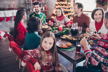 Fototapeta na wymiar Photo portrait little girl wearing sweater celebrating winter holidays with family sitting at table on new year