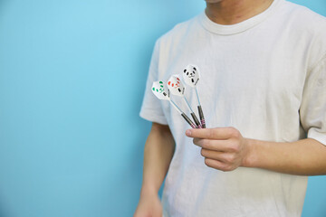 ダーツを持つ男性の手元のクローズアップ