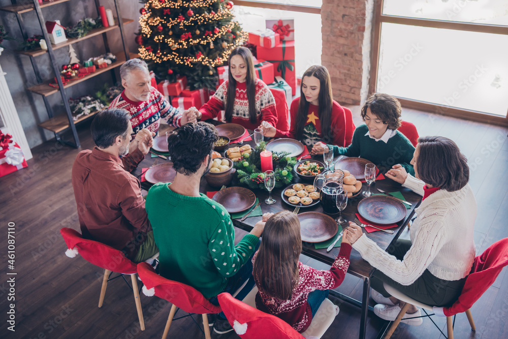 Poster Portrait of adorable dreamy cheerful family eating festal homemade lunch dish praying at home indoors