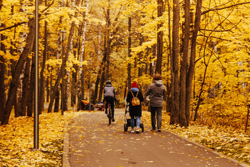 Fototapeta premium love, parenthood, family, season and people concept - smiling couple with baby pram in autumn park