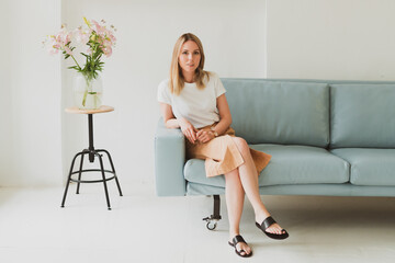 Obraz premium charming young woman sitting on the sofa at home