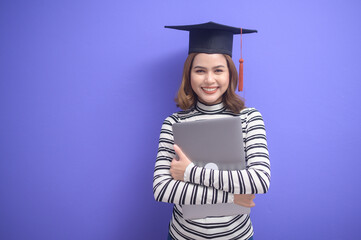 Portrait of young woman graduated over blue background