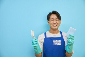 掃除用具をもってほほ笑む　日本人男性