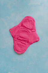 Cloth menstrual pad against blue extendable background with copy space. Reusable, biodegradable, eco friendly sanitary napkins