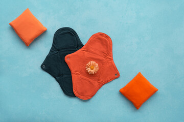 Cloth menstrual pads that are reusable, biodegradable, eco friendly. Pads of different sizes for easy usage against blue textured background with copy space