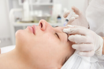 Cosmetologist does injections for anti wrinkle of beautiful woman. Women's cosmetology in beauty salon