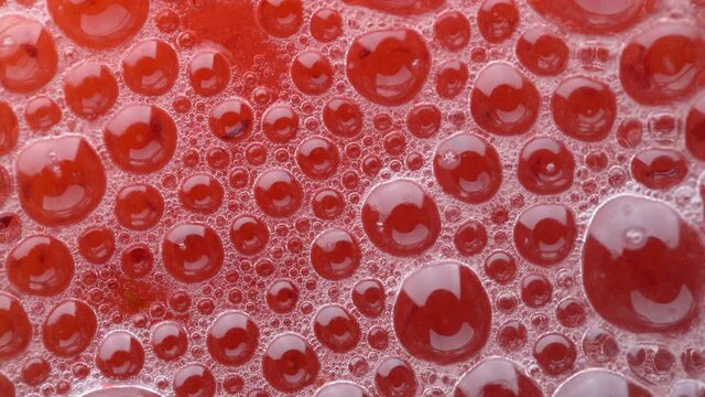 Bubbles on the surface of the drink of red viburnum soda drink on background. Fresh drink of scarlet cranberry or cherry or red currant or viburnum