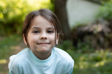 Close-up portrait of little beautiful biracial asian girl on blurred rustic background with lovely bokeh