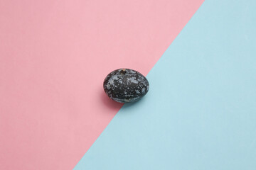 Gray marble painted Easter egg on pink blue background. Top view. Minimalism
