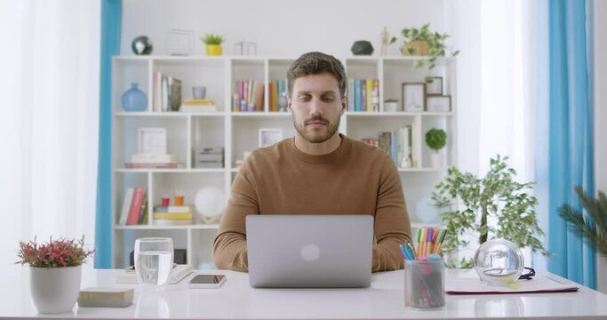 Dolly Out of Confident Handsome Caucasian Brunette Man Opening and Typing on Laptop, Young Bearded Male Professional Writing an Important Email From his Home in Modern Living Room. Remote Working 