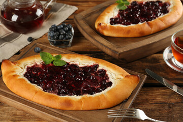 Delicious sweet cottage cheese pastry with cherry jam on wooden table