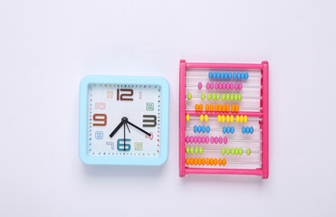 Childrens toy abacus and clock on white background. Top view