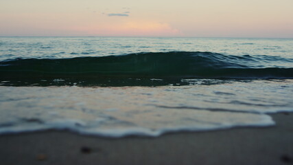 Fototapeta premium Blue sea waves breaking sand beach seashore in summer morning in slow motion. 