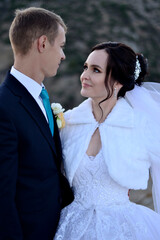 Young bride and groom in the mountains near the sea