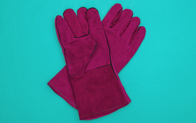 Pink Work gloves on blue background. Top view