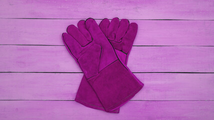 Work gloves on pink wooden background. Top view