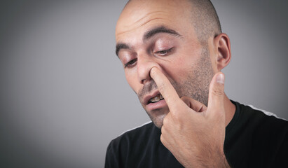 Young man with finger in his nose.