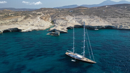 Aerial drone photo of luxury yacht anchored near famous white chalk volcanic bay of Sarakiniko, Milos island, Cyclades, Greece