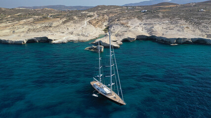 Aerial drone photo of luxury yacht anchored near famous white chalk volcanic bay of Sarakiniko,...