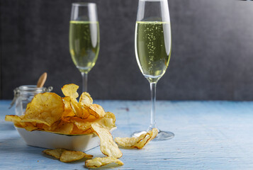 Homemade vegan salt chips. Homemade crisps, chips made from vegan potatoes fried in sunflower oil. With champagne . © peter