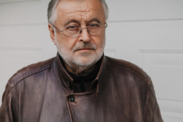 Handsome elderly man with glasses and leather jacket