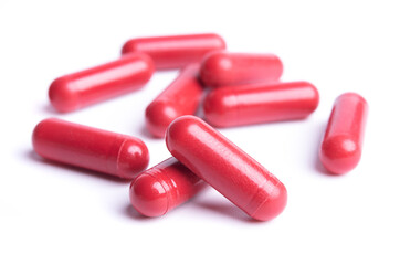 Red pills in capsules isolate on white background