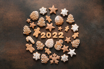 Obraz na płótnie Canvas Creative Christmas composition as ball of assorted cookies with date 2022 inside on a brown background. New Year greeting card. Top view. Xmas festive holiday.