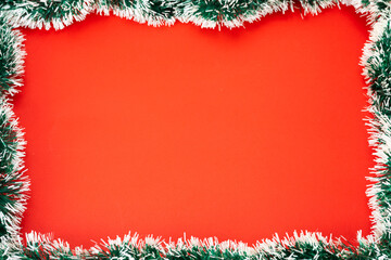 Fototapeta na wymiar Christmas red background in a frame of tinsel.