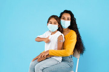 Vaccinated Arabic Girl And Her Mom Gesturing Thumbs-Up, Blue Background