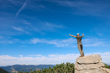 Man enjoying picturesque view on cliff in mountains. Space for text