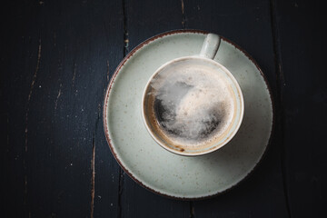 Mug of hot coffee on a wooden board