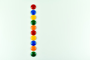 Kolorowe, plastikowe magnesy na kolorowych kartkach papieru.
