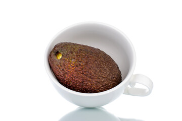 One ripe avocado with pottery crockery, close-up, isolated on white.