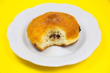 Bitten Donut with chocolate on plate. Delicious sweets temptation and desserts on a yellow background. Minimalism, original and creative image. Beautiful food wallpaper.