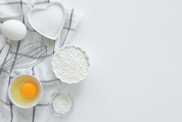 Fototapeta na wymiar Ingredients set for baking. Cooking pie, cake. Flour, eggs, sugar for sweet pastries on white background. Top view, copy space. Culinary light background