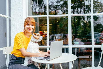 Adult tired upset woman work at cafe outdoor with dog remote workers and smart working day professional job typing on computer laptop, online modern people work writing on notebook and think