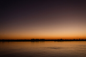 Dark sunset with the water of the river.