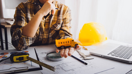 Two colleagues discussing data working and tablet, laptop with on on architectural project at construction site at desk in office