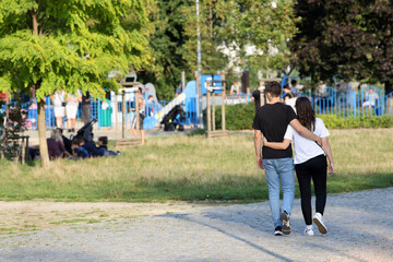 Para młodych ludzie, kobieta i mężczyzna spaceruje deptakiem, chodnikiem we Wrocławiu.	