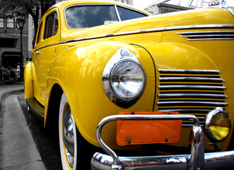 A close up picture from front left side of a retro yellow taxi car 