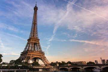 The Eiffel Tower at a beautiful sunset with blue sky and clouds.