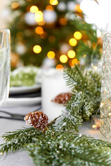 Festive Christmas decorations a pine branch with cones decorate the dinner table