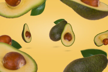 Fresh ripe whole and sliced avocado flying in air isolated on pastel yellow background.